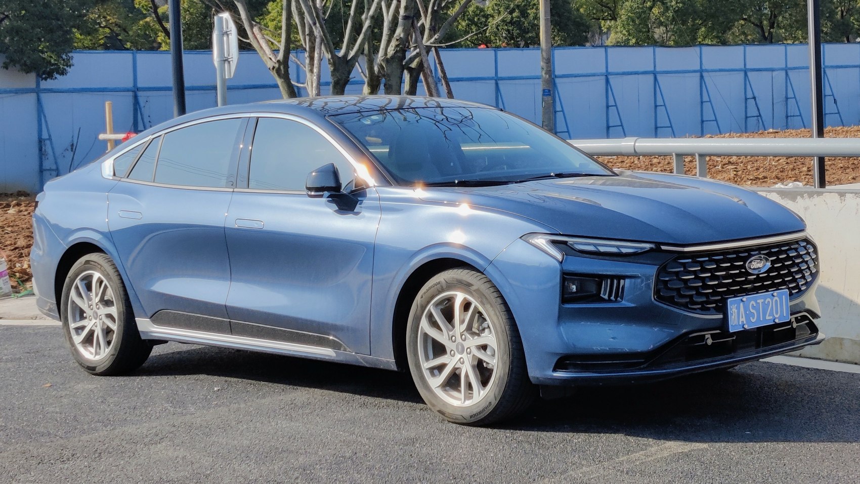 Sleek blue sedan front side profile with modern grille and alloy wheels