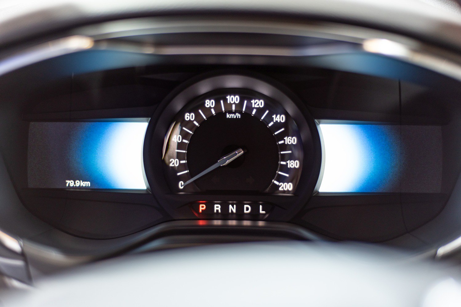 Digital speedometer and gear shift indicator illuminated in a car dashboard