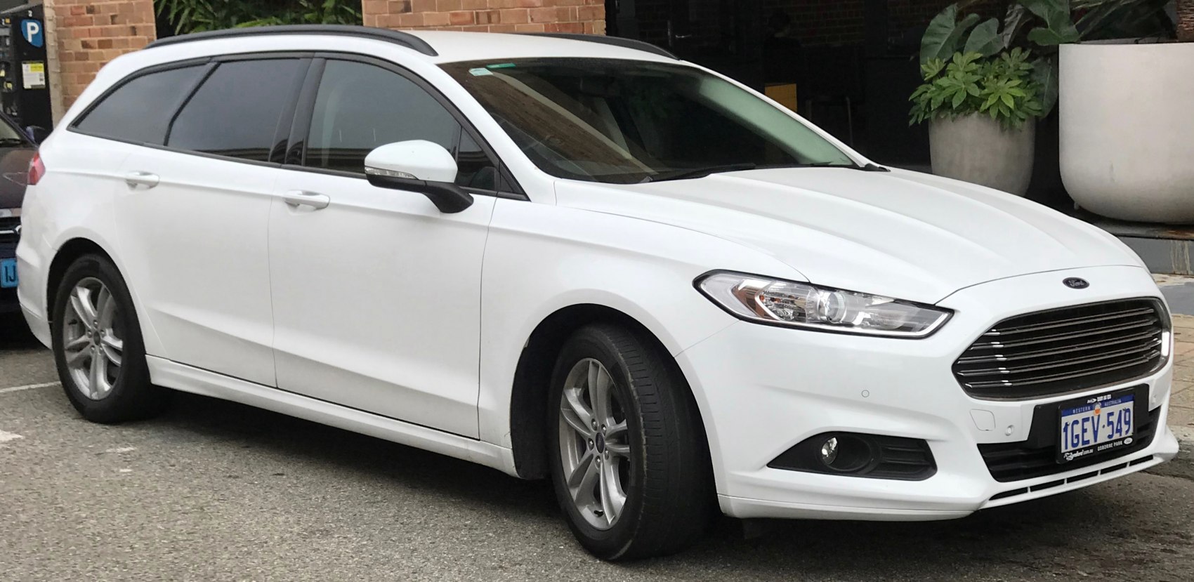 White wagon with front grille, alloy wheels, and tinted windows