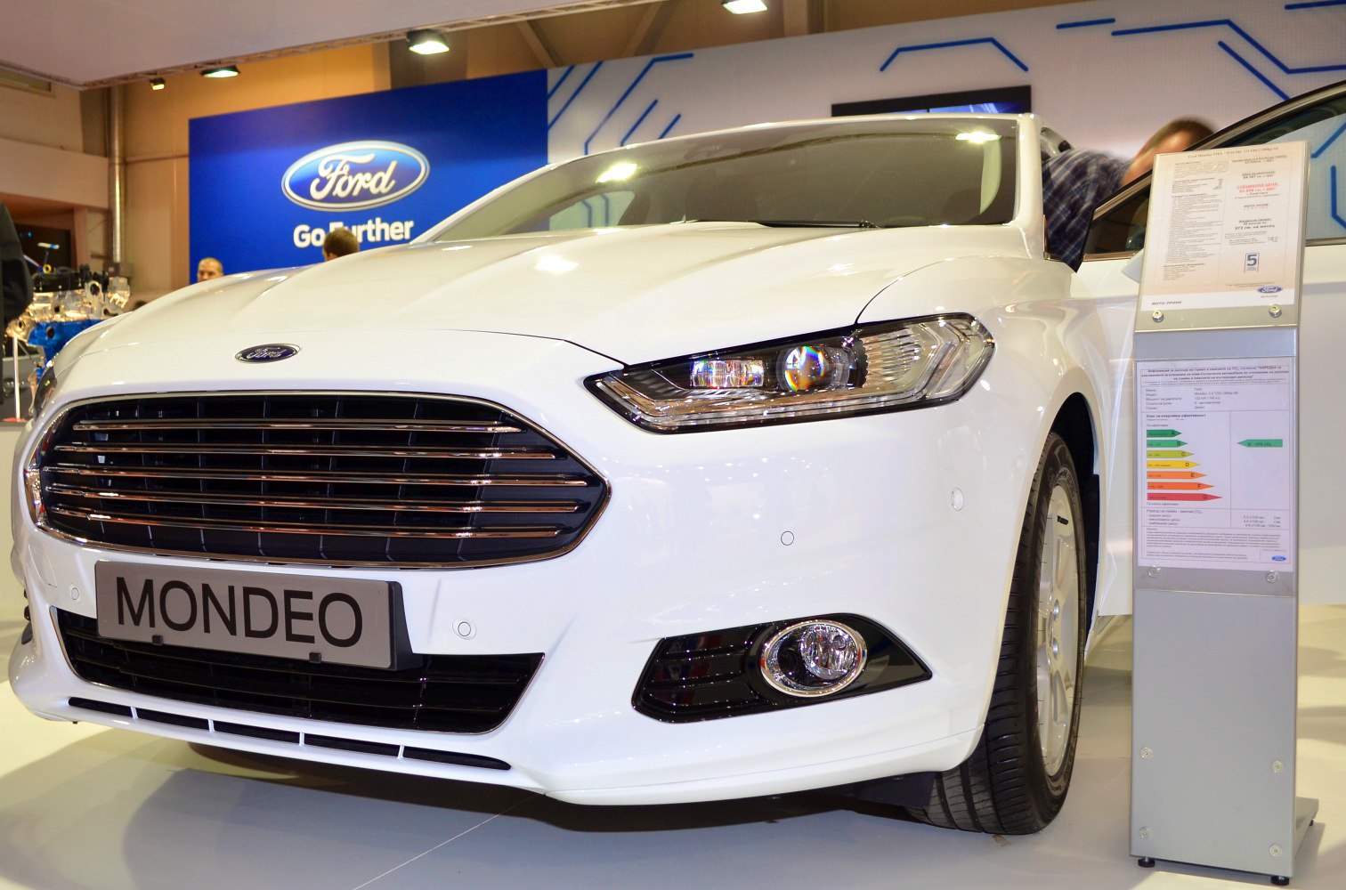 Front grille and headlight close-up of a white sedan.