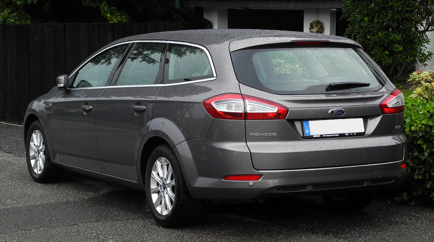 Rear profile and taillights of a station wagon on a rainy day