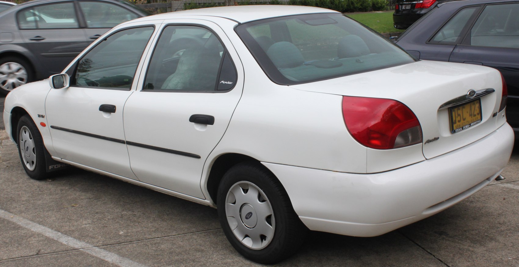 Rear and side view of a mid-90s sedan with rounded taillights and smooth body lines