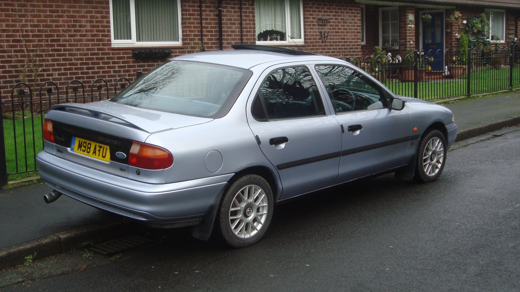 Rear side view of a sedan with rear spoiler and alloy wheels
