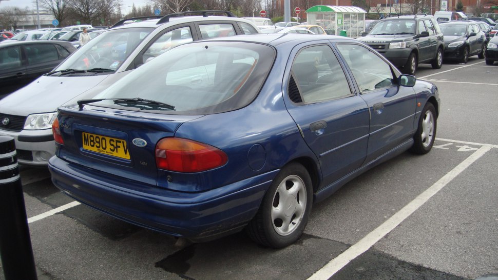 Rear and side view of a 1990s hatchback with distinct rounded taillights and four doors