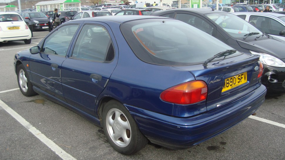 Rear and side view of a 90s hatchback with distinct tail lights and hatchback design