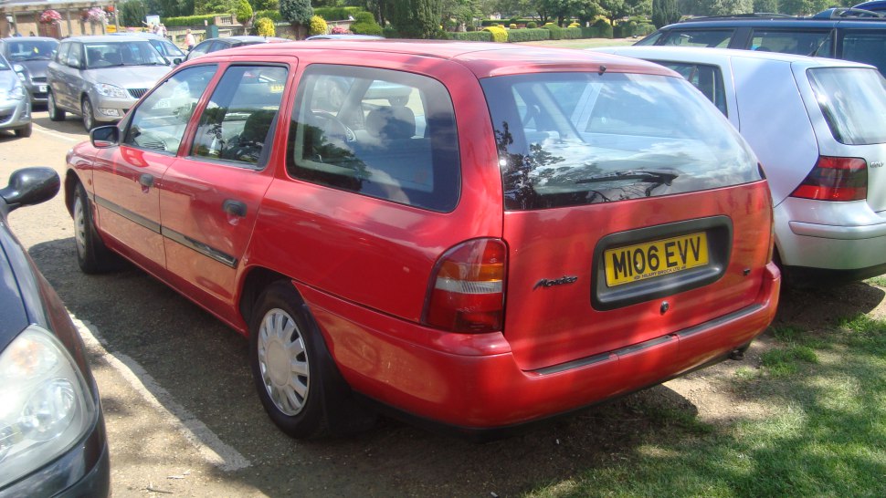 Rear side view of a red 1990s station wagon with hatchback design