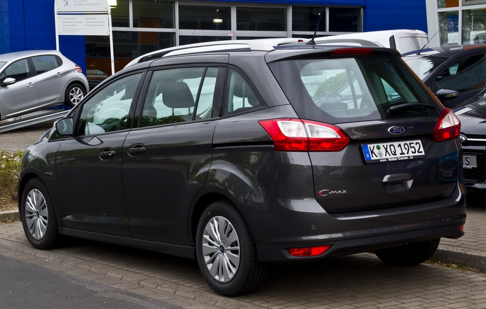 Rear and side view of a compact MPV with distinctive tail lights and roof rails.