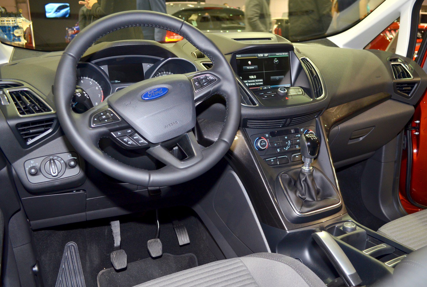 Steering wheel, manual gear shift, dashboard controls, and infotainment display
