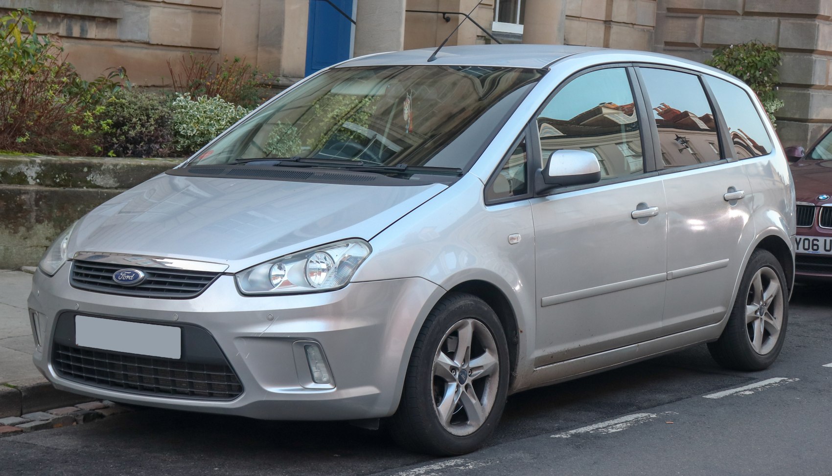 Front side view showing headlamp, grille, and alloy wheels of a compact MPV.