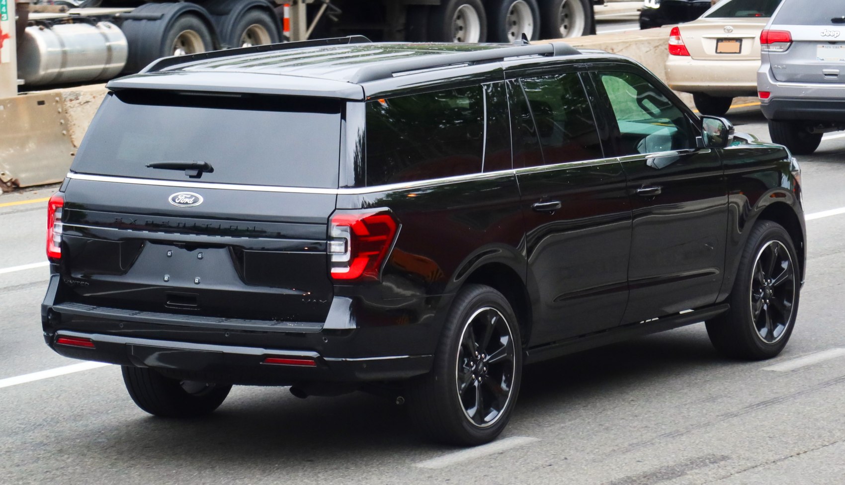 Rear view of a black full-size SUV with tinted windows and modern taillight design