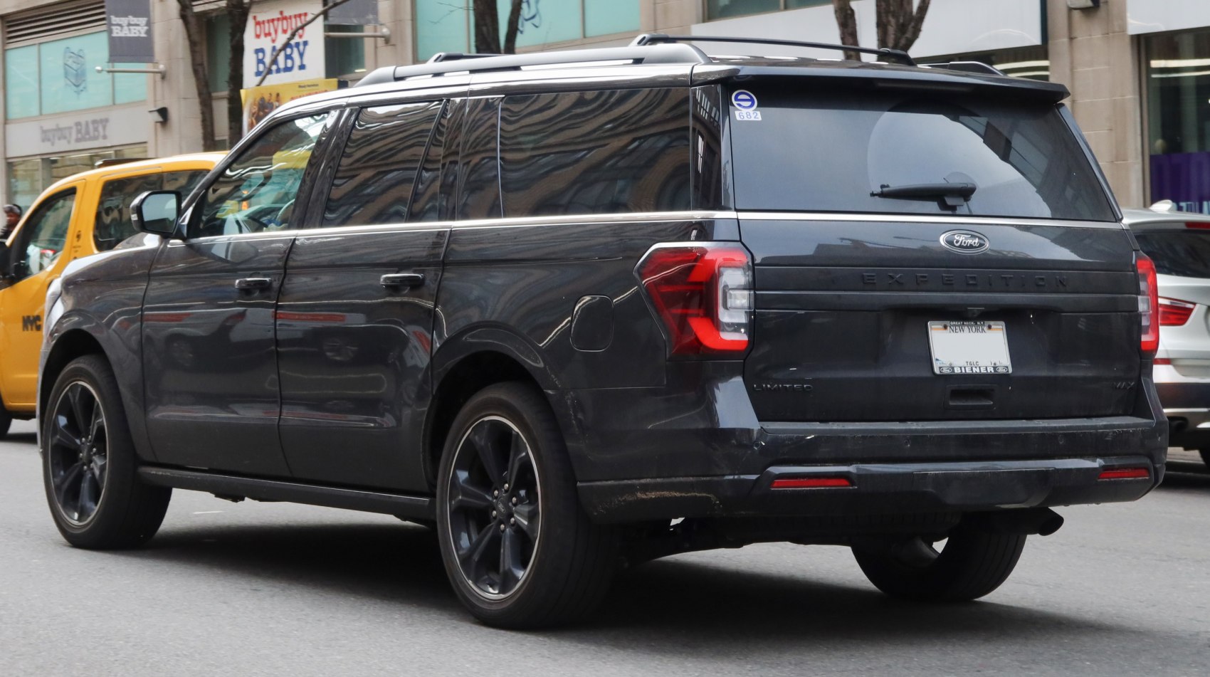 Rear side view of black full-size SUV with tinted windows and black wheels