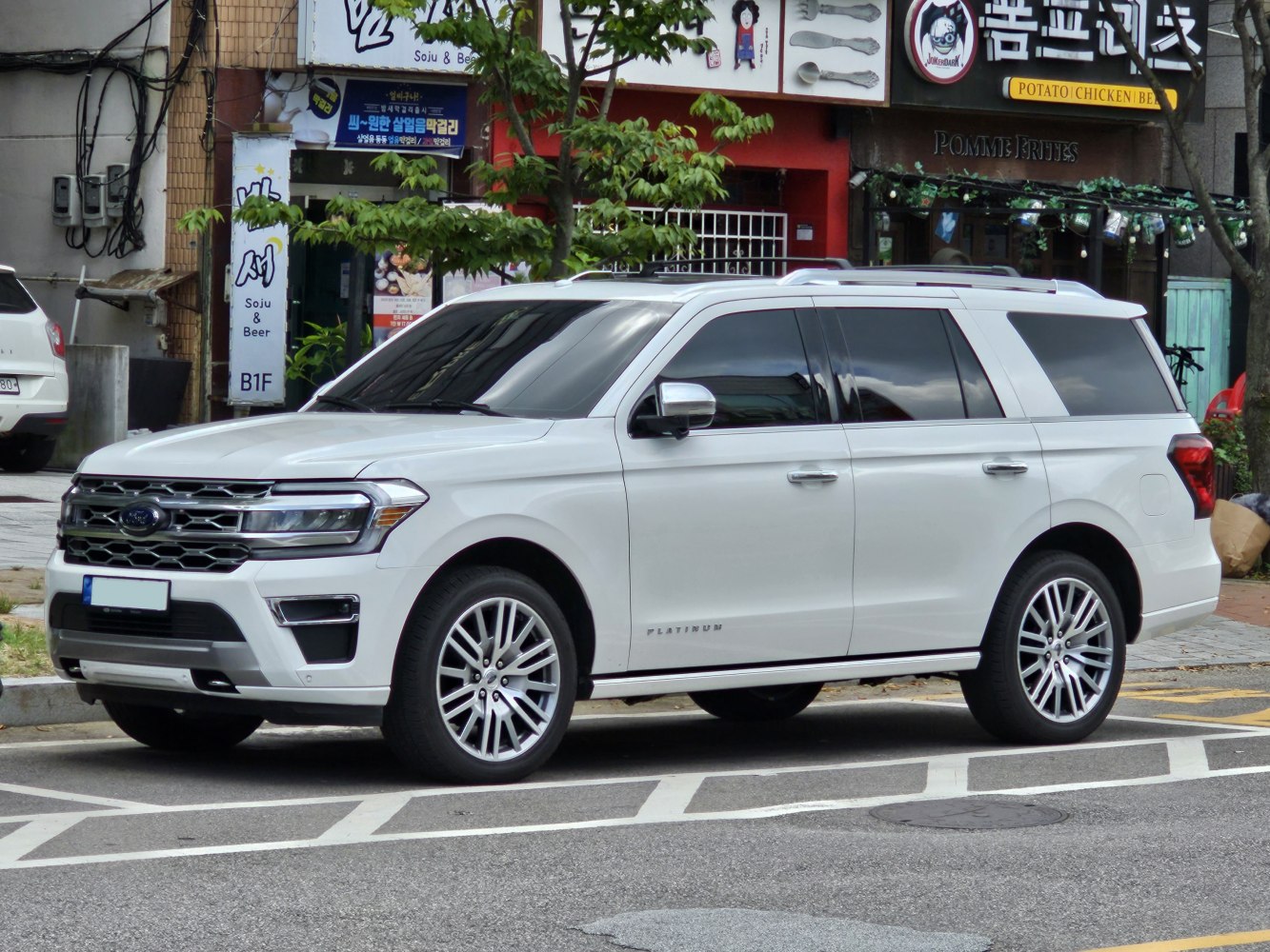 White full-size SUV with chrome grille and large alloy wheels