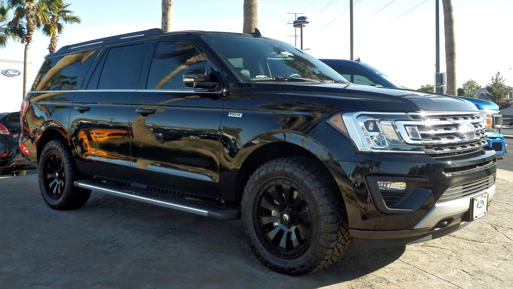 Black SUV with off-road tires and chrome grille