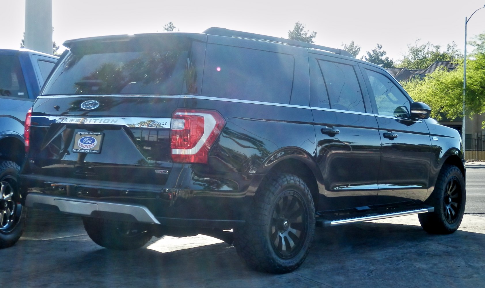 Black large SUV with off-road wheels and rear taillights