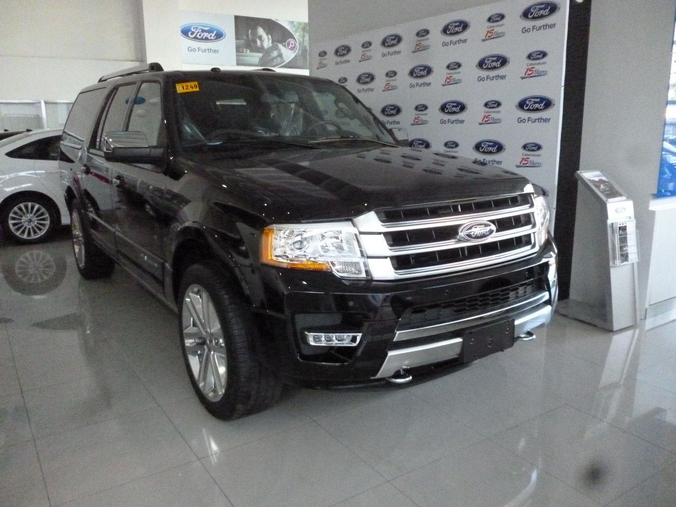 Front angled view of large black SUV with chrome grille and LED fog lights