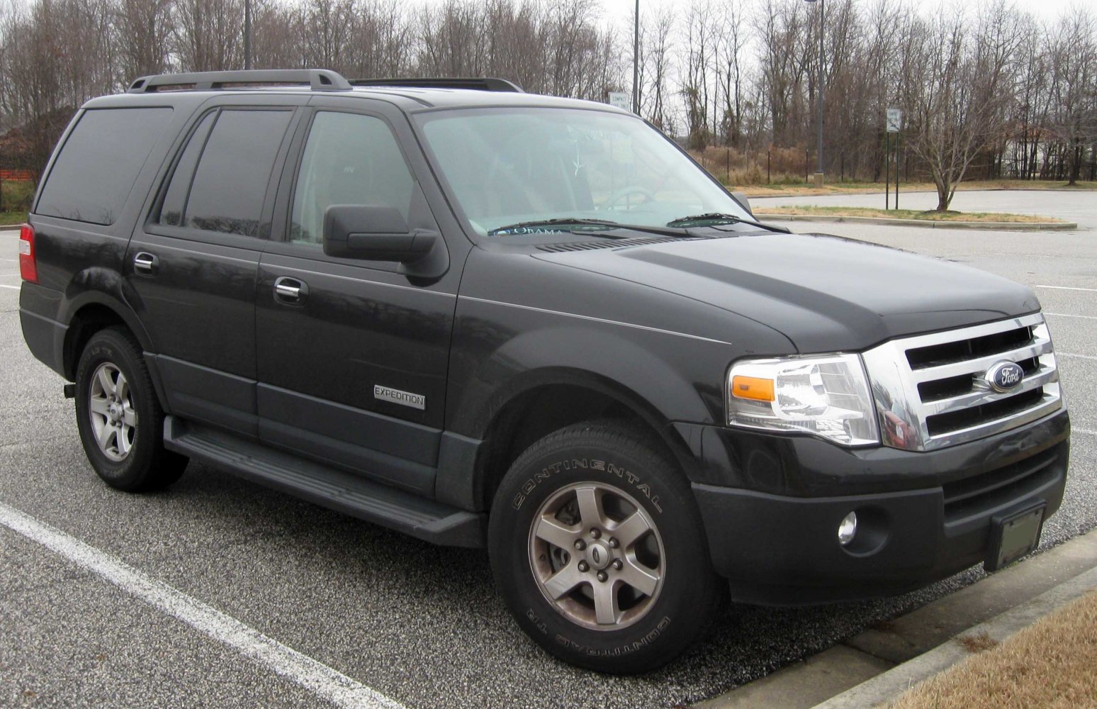 Large SUV with roof rails, side step bars, and alloy wheels