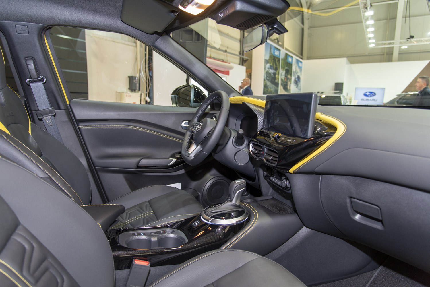 Modern car interior with touchscreen dashboard and yellow stitching