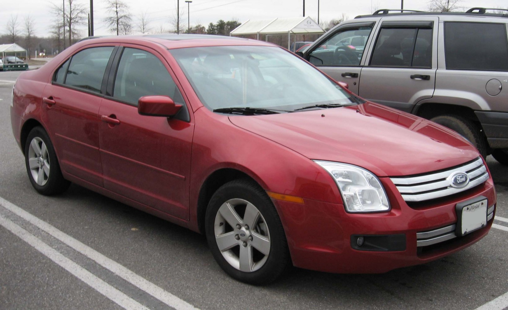 Red midsize sedan with alloy wheels and chrome grille