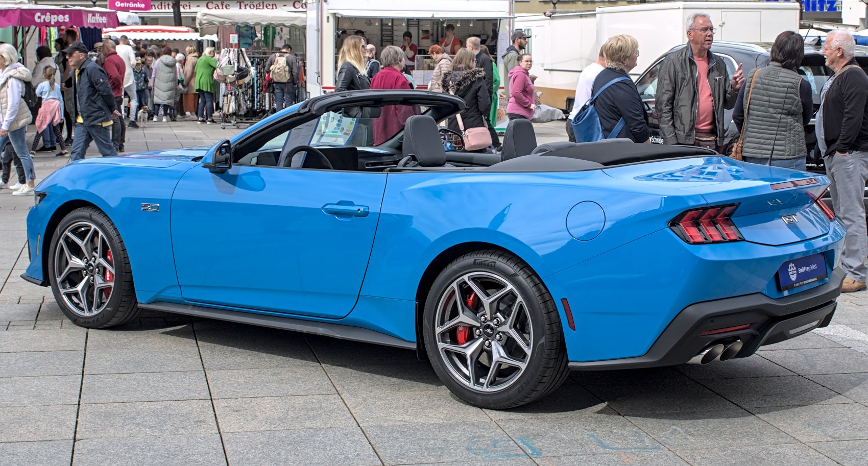 Bright blue sleek convertible with sporty wheels and dual exhaust