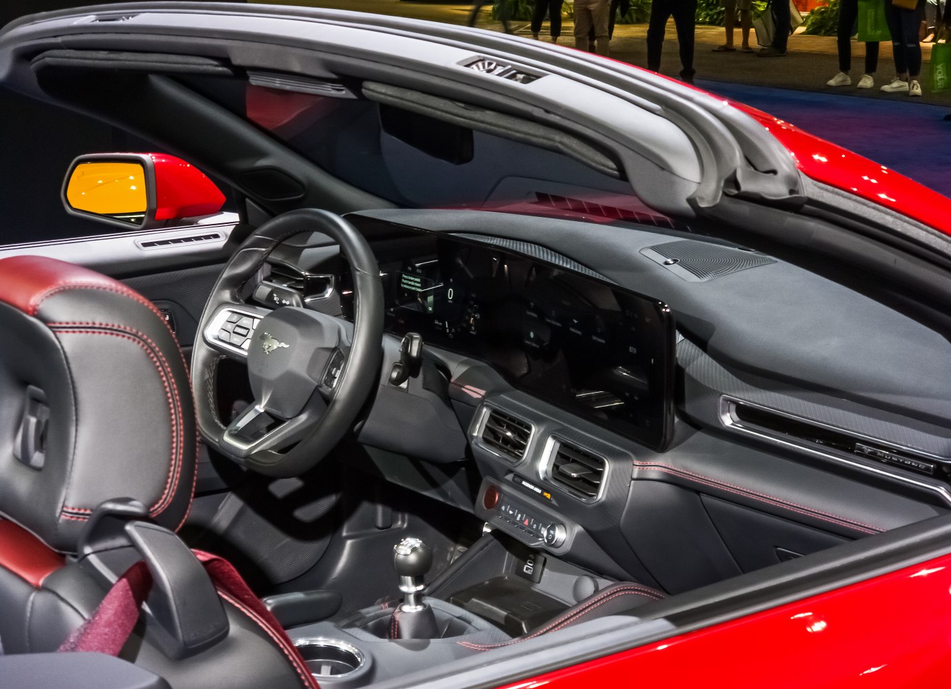 Interior view showing dashboard, digital display, steering wheel, and manual gear shifter