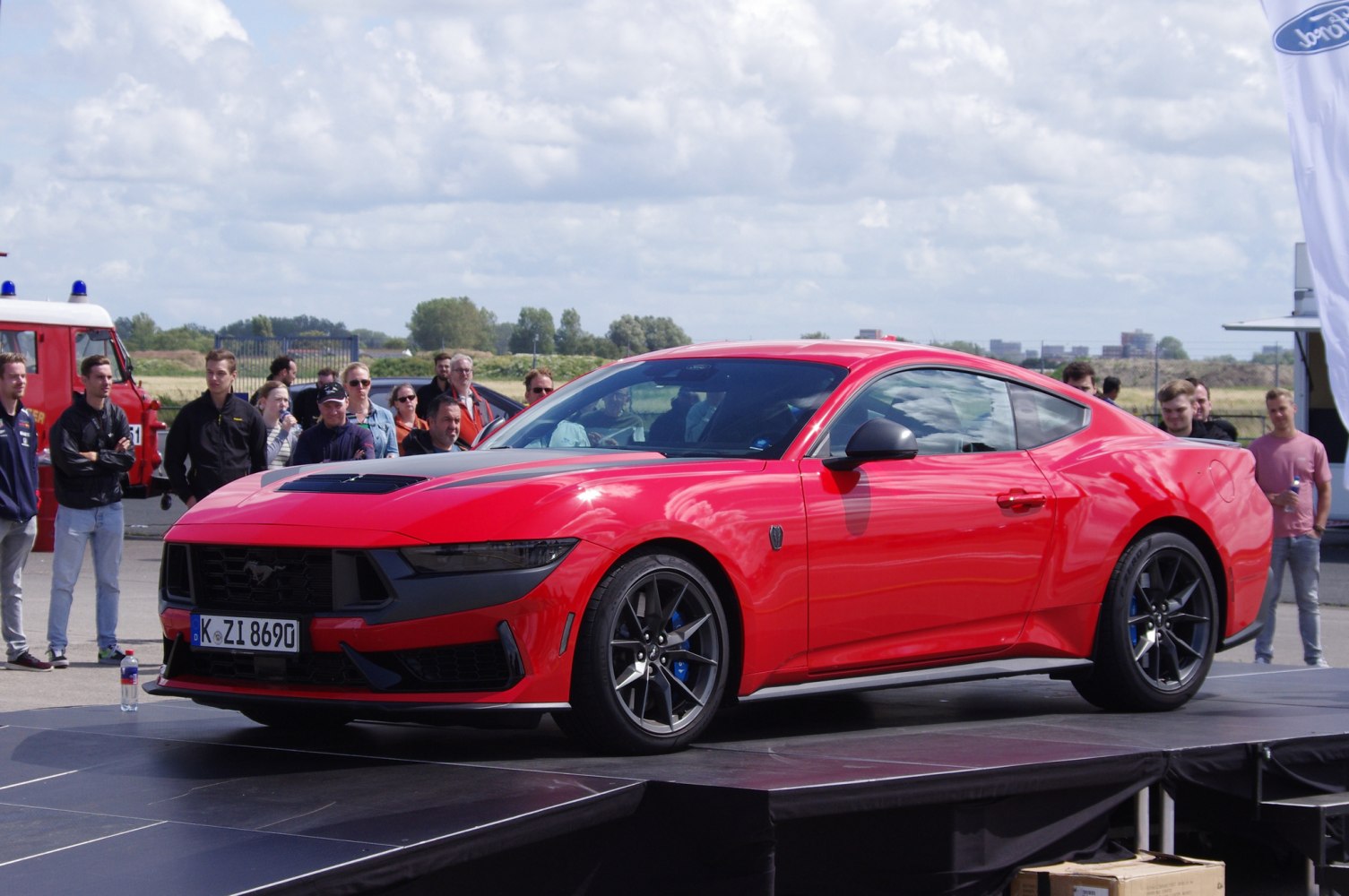 Red sports coupe with aggressive front grille and black alloy wheels