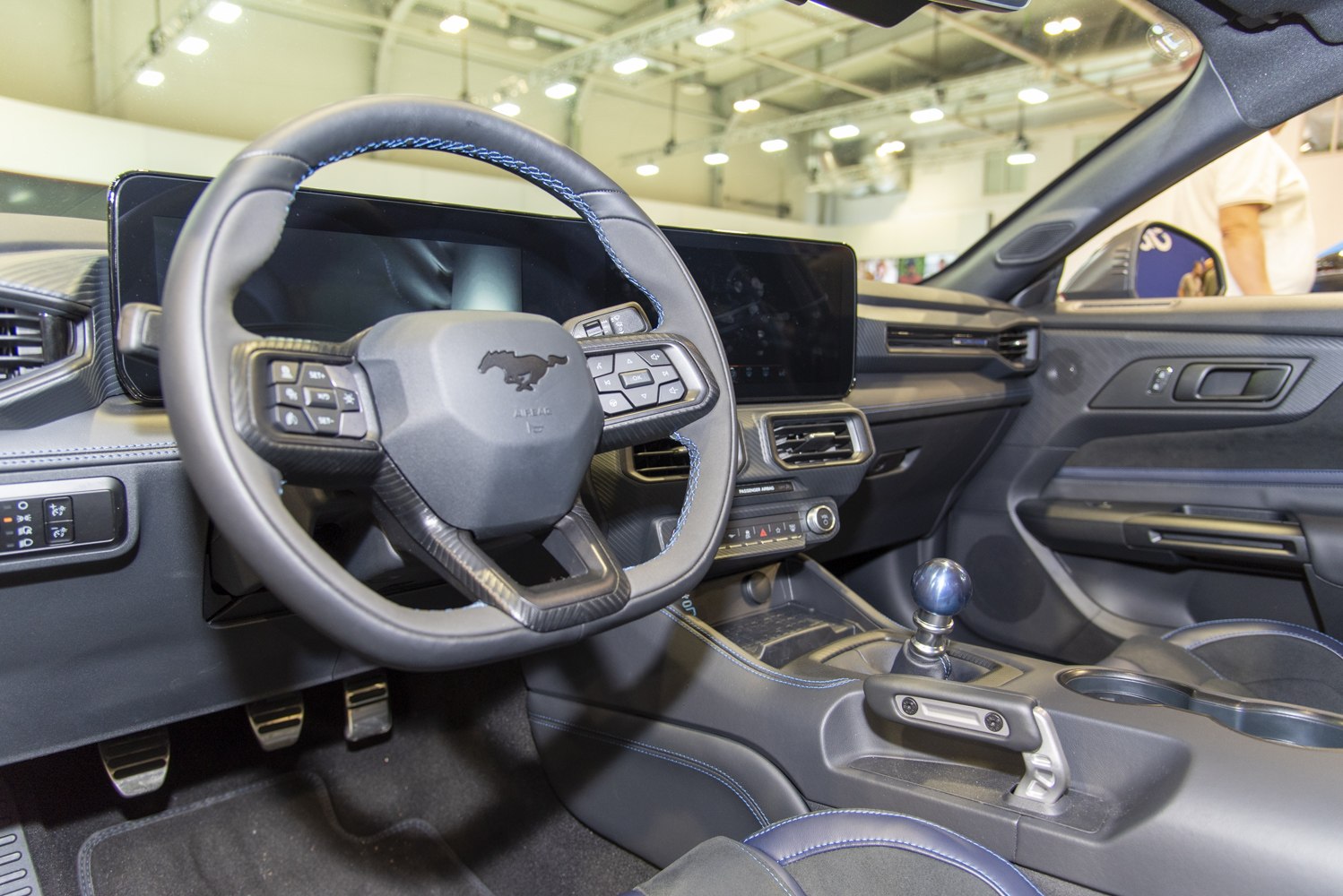Manual gear shifter and digital dashboard inside a sporty car interior