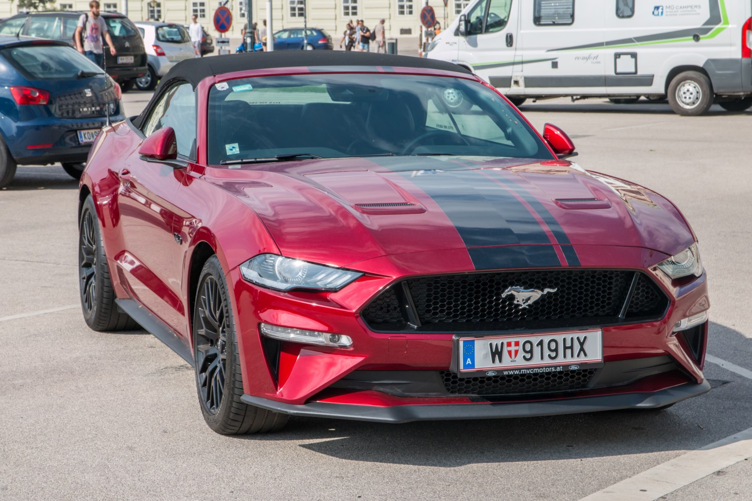 Red convertible with black racing stripes and aggressive front design