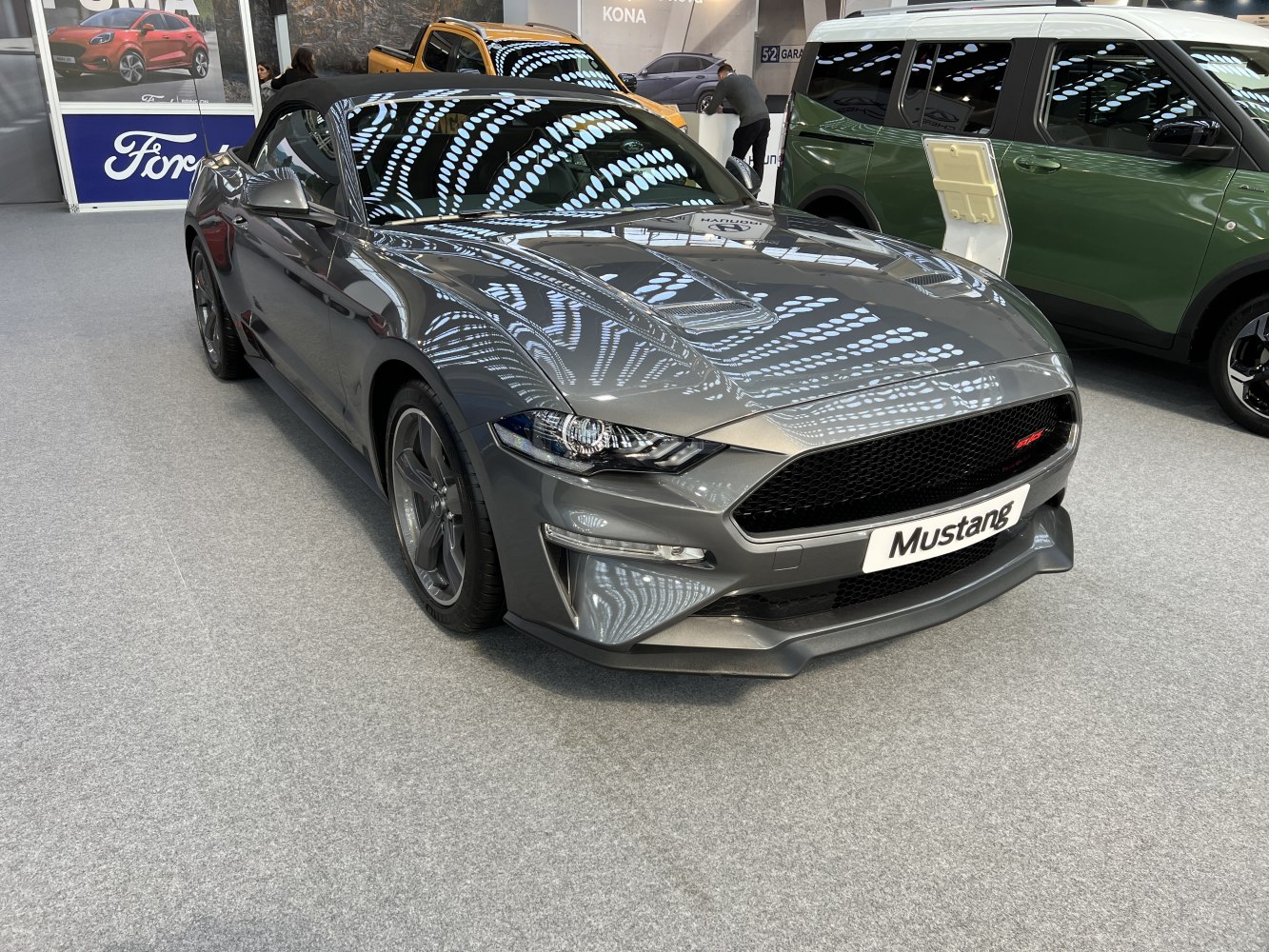 Front view of sleek convertible with sharp headlights and large grille