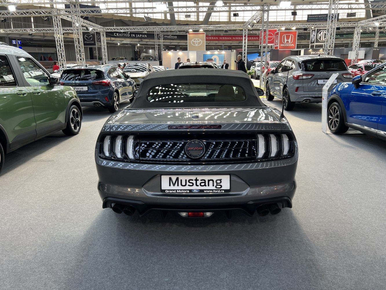 Rear view of a convertible with tri-bar taillights and black soft top