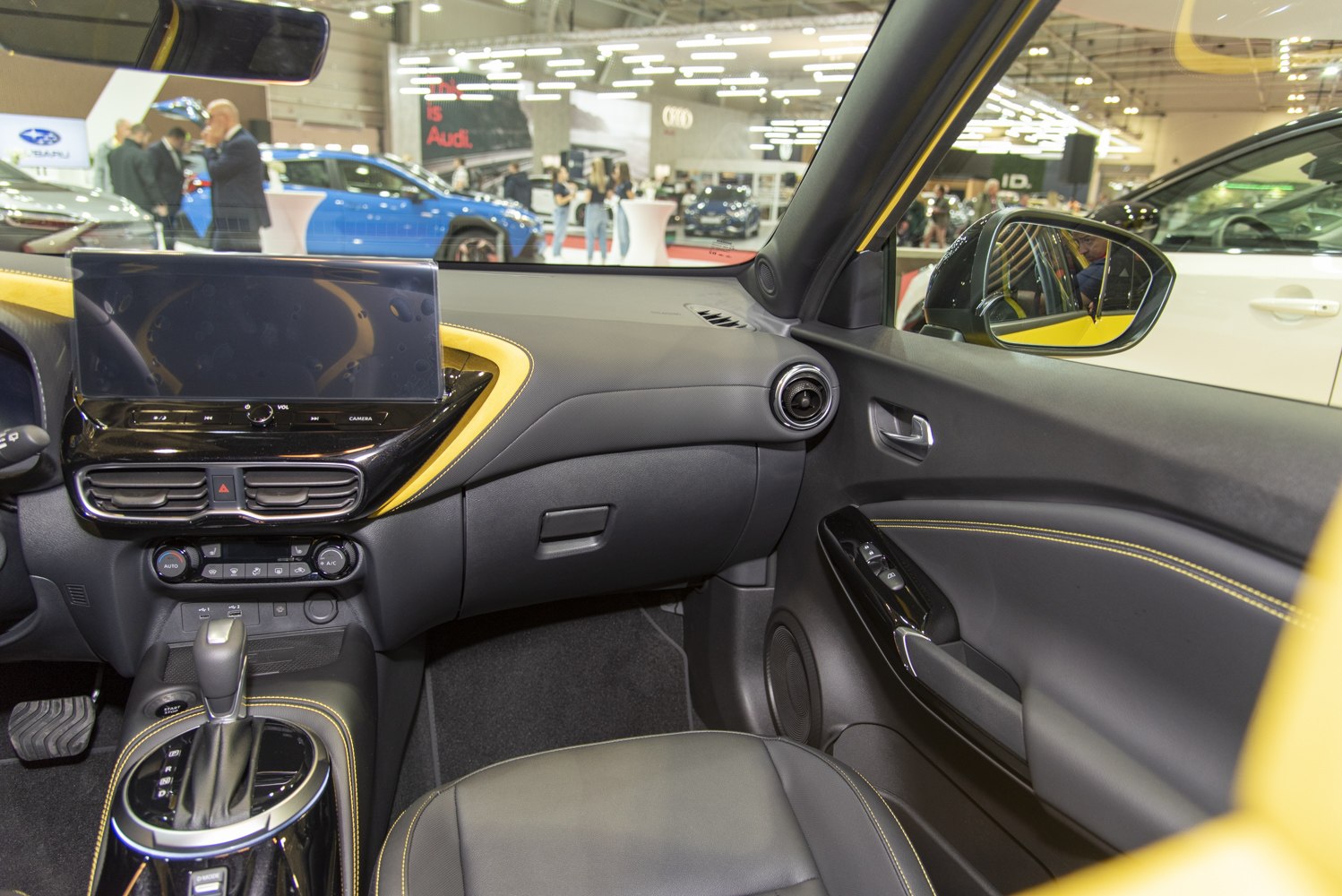 Modern car interior with digital display and yellow stitching