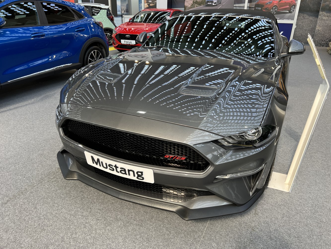 Aggressive front with black grille, hood scoops, sharp headlights