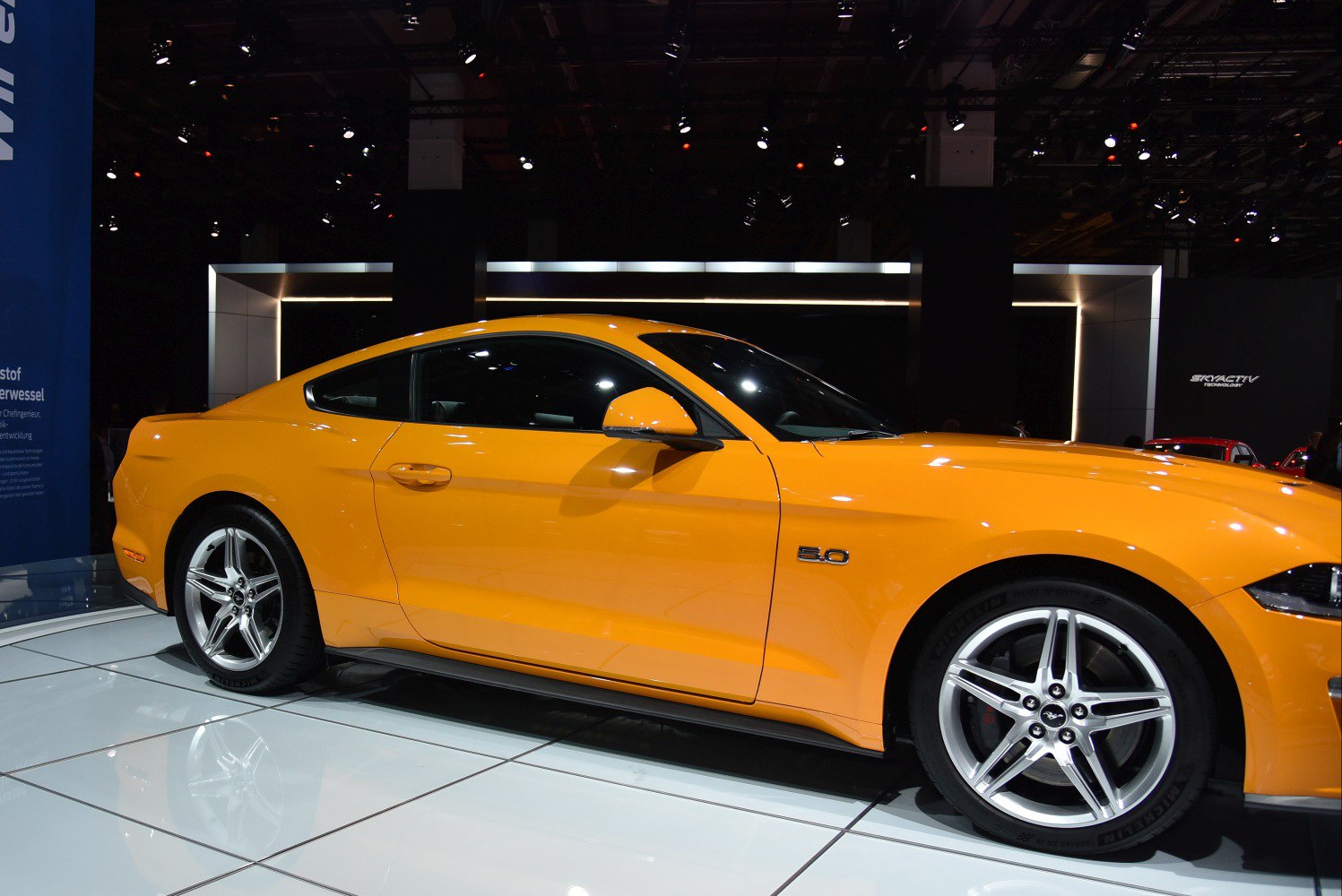 Side profile of a sports coupe with 5.0 badge and five-spoke alloy wheels