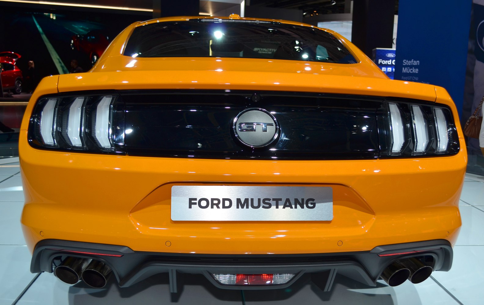 Rear view with taillights, quad exhaust tips, and black panel