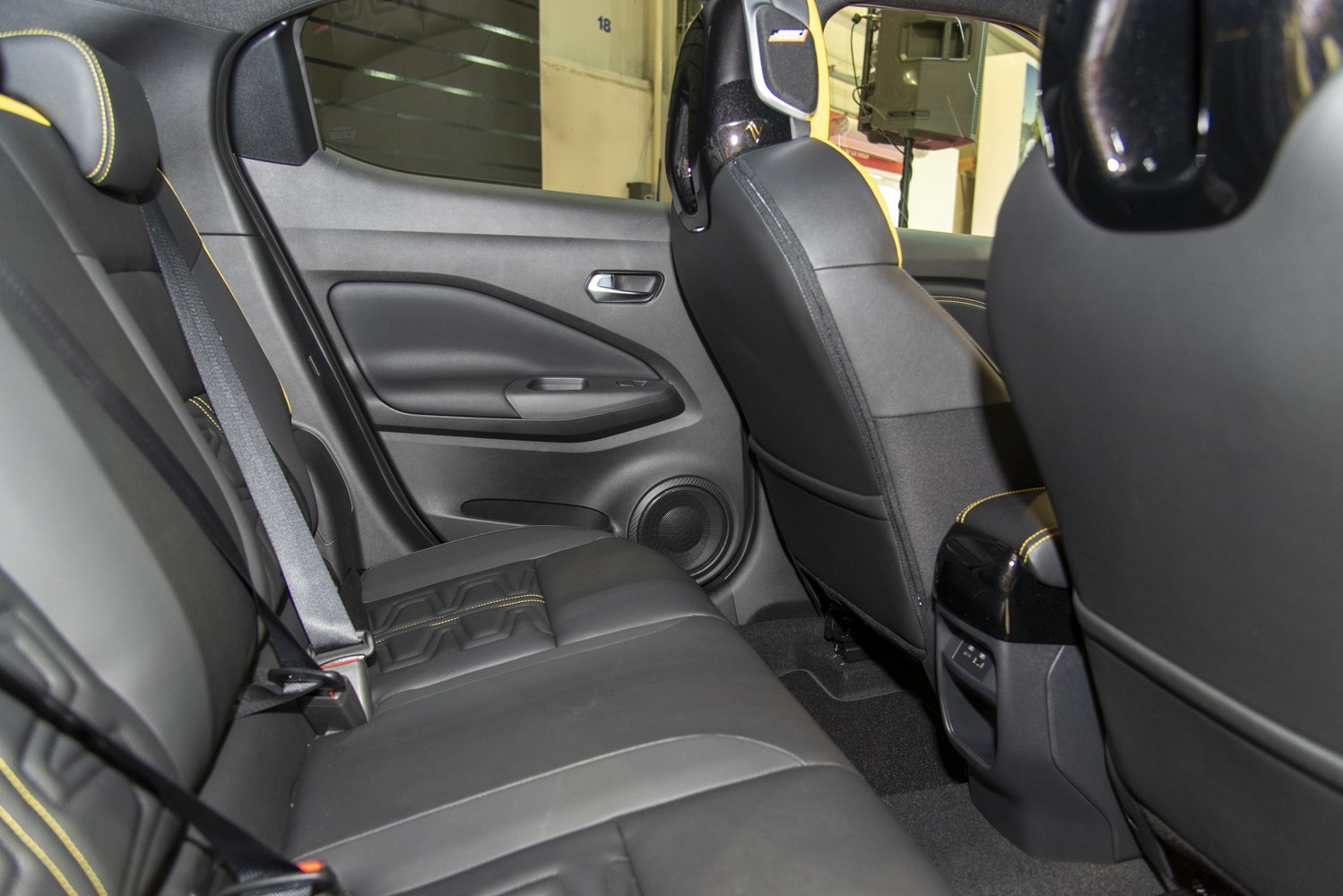 Rear interior with black leather seats and yellow stitching
