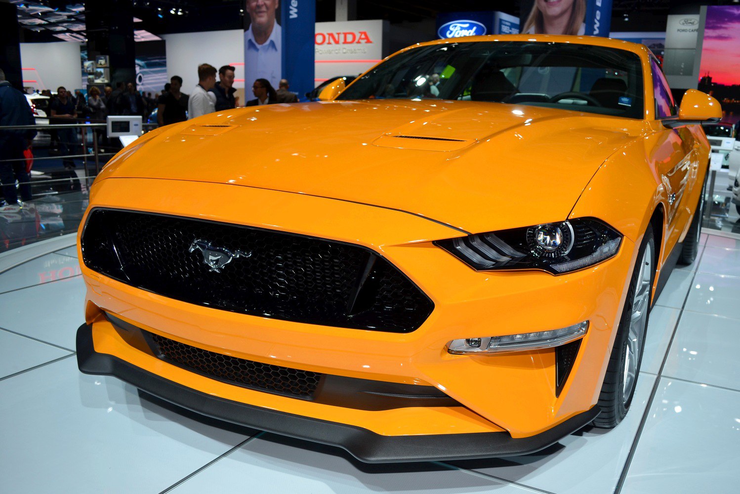 Aggressive black front grille and sharp LED headlights on vibrant orange exterior