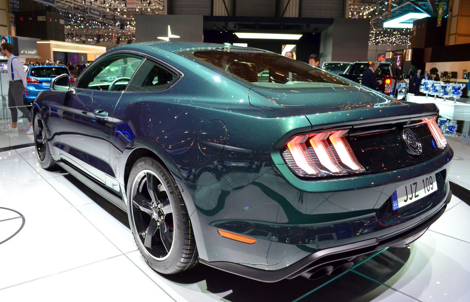 Rear view of sporty coupe with triple-bar tail lights and black rims