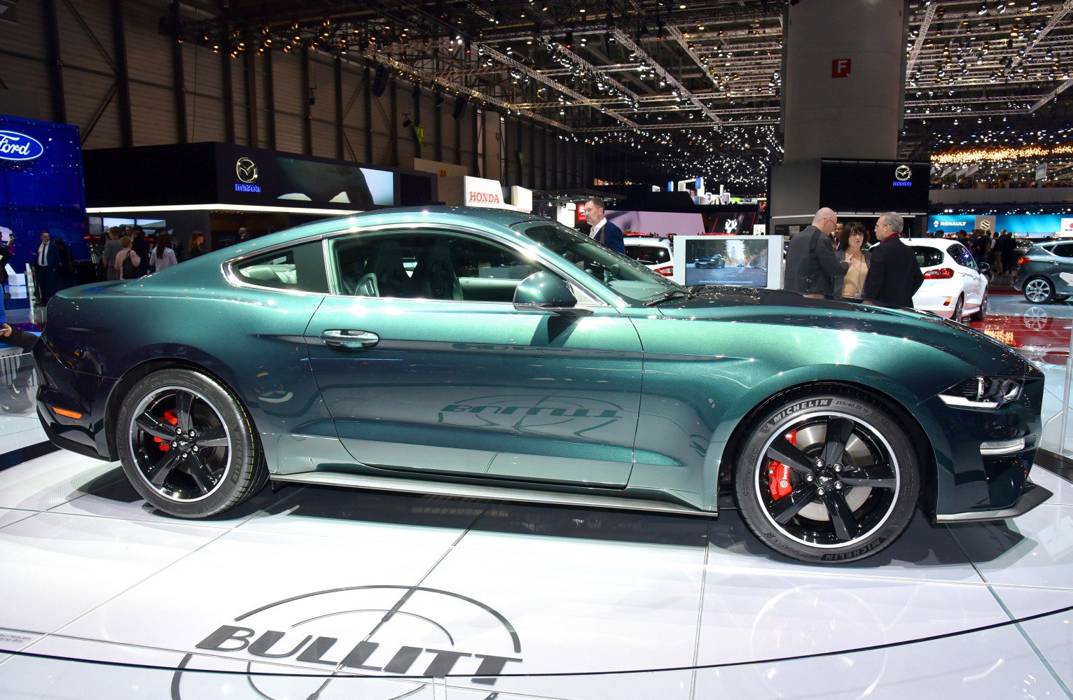 Sleek side profile of a sport coupe with black alloy wheels and distinctive body lines.