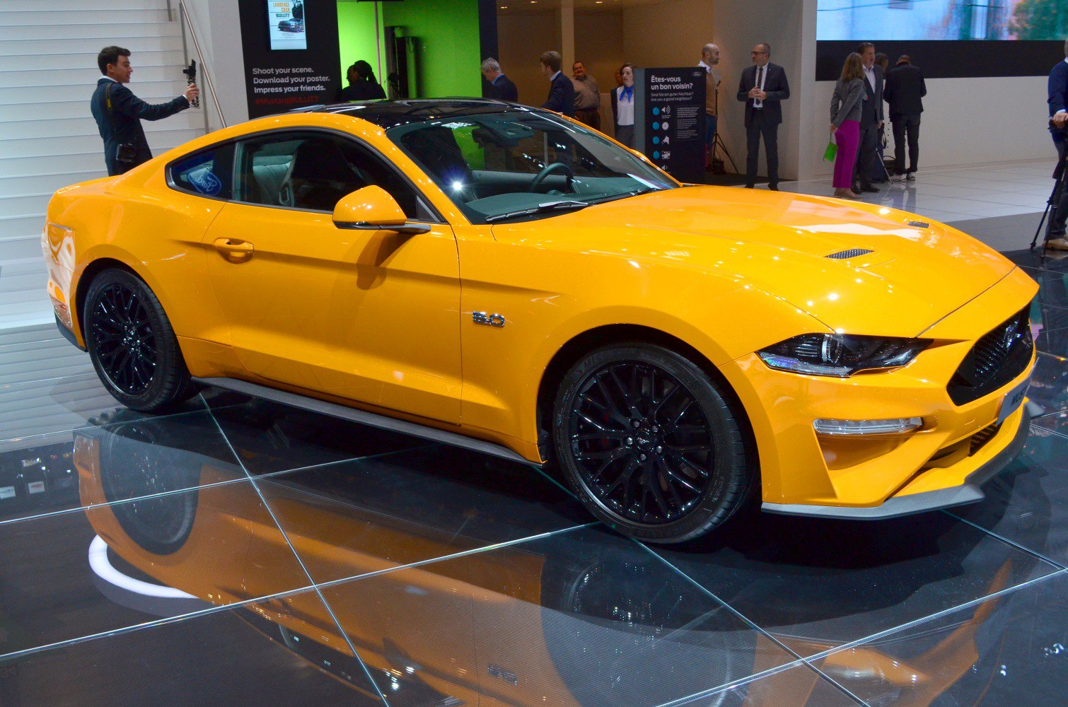 Yellow sporty coupe with black alloy wheels and aggressive front design