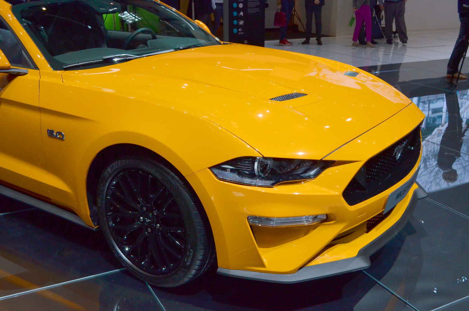 Yellow Mustang front end with headlights and black wheels