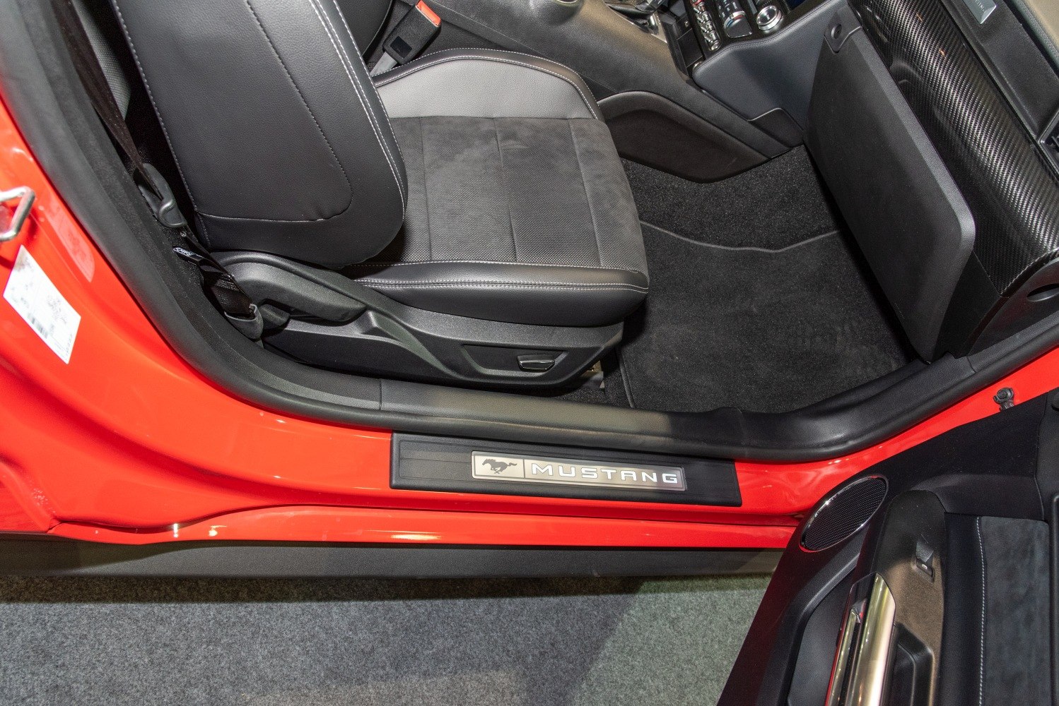 Driver seat and illuminated Mustang door sill plate in car interior