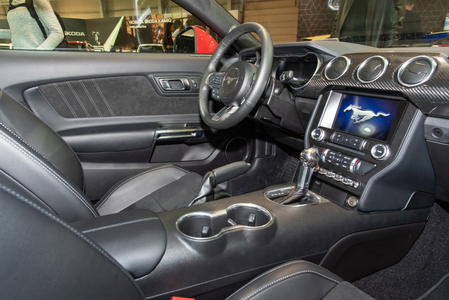 Leather seats, steering wheel with controls, touchscreen multimedia, gear shifter, and air conditioning vents.