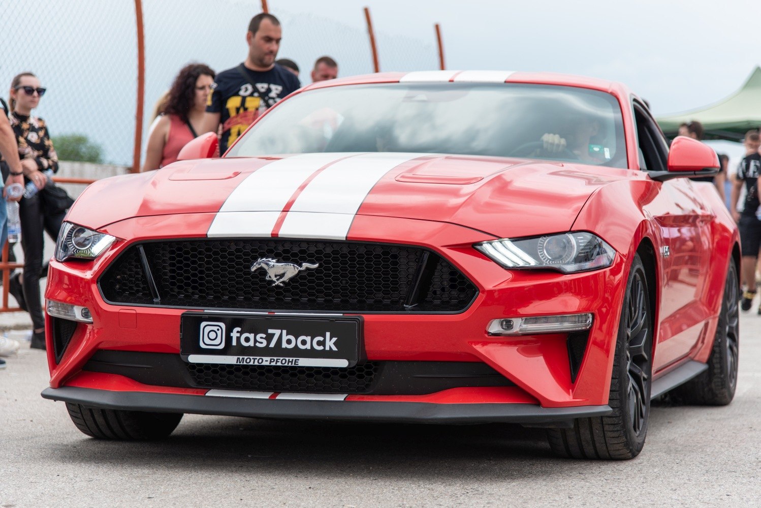Close-up front view with dual racing stripes and aggressive grille