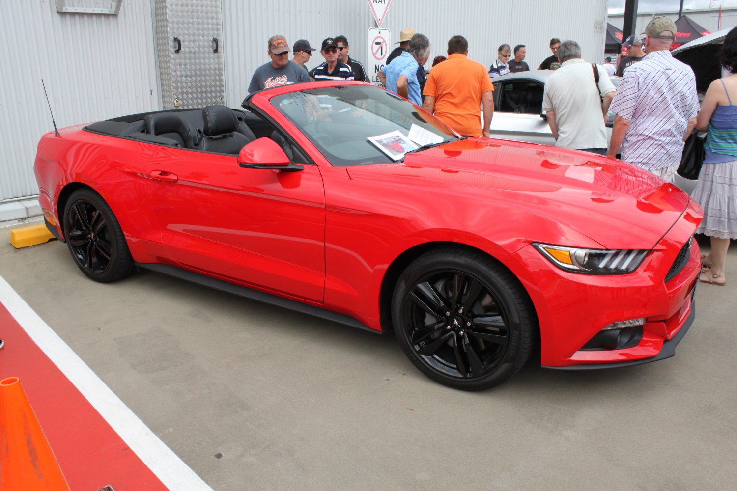 Red convertible with black rims and open roof