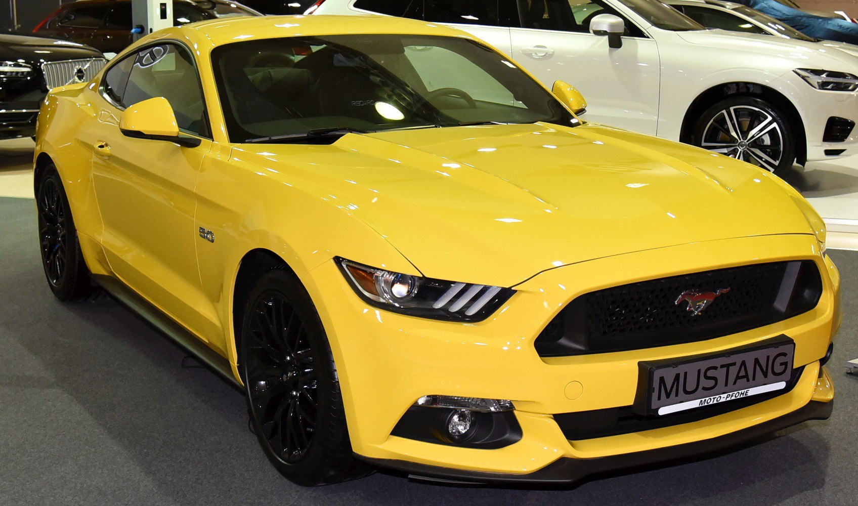 Yellow coupe with black wheels and aggressive front fascia