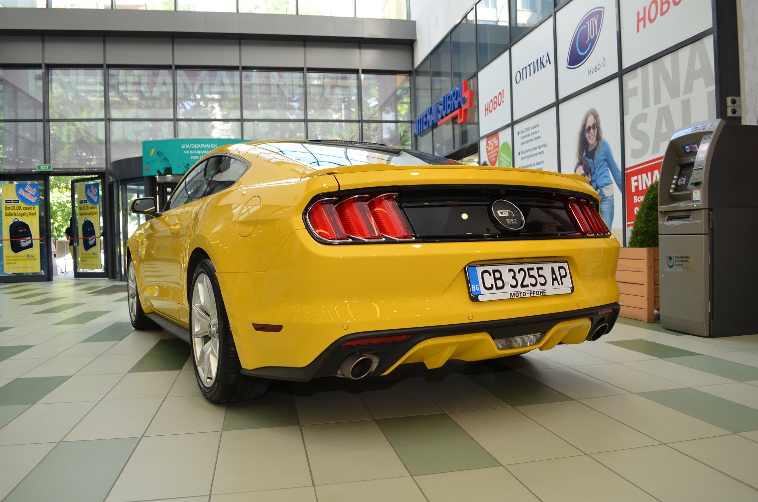 Rear view of yellow sports coupe with distinct LED tail lights and dual exhaust