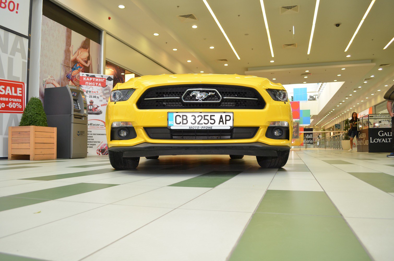 Front grille and headlights of a yellow muscle car with pony emblem