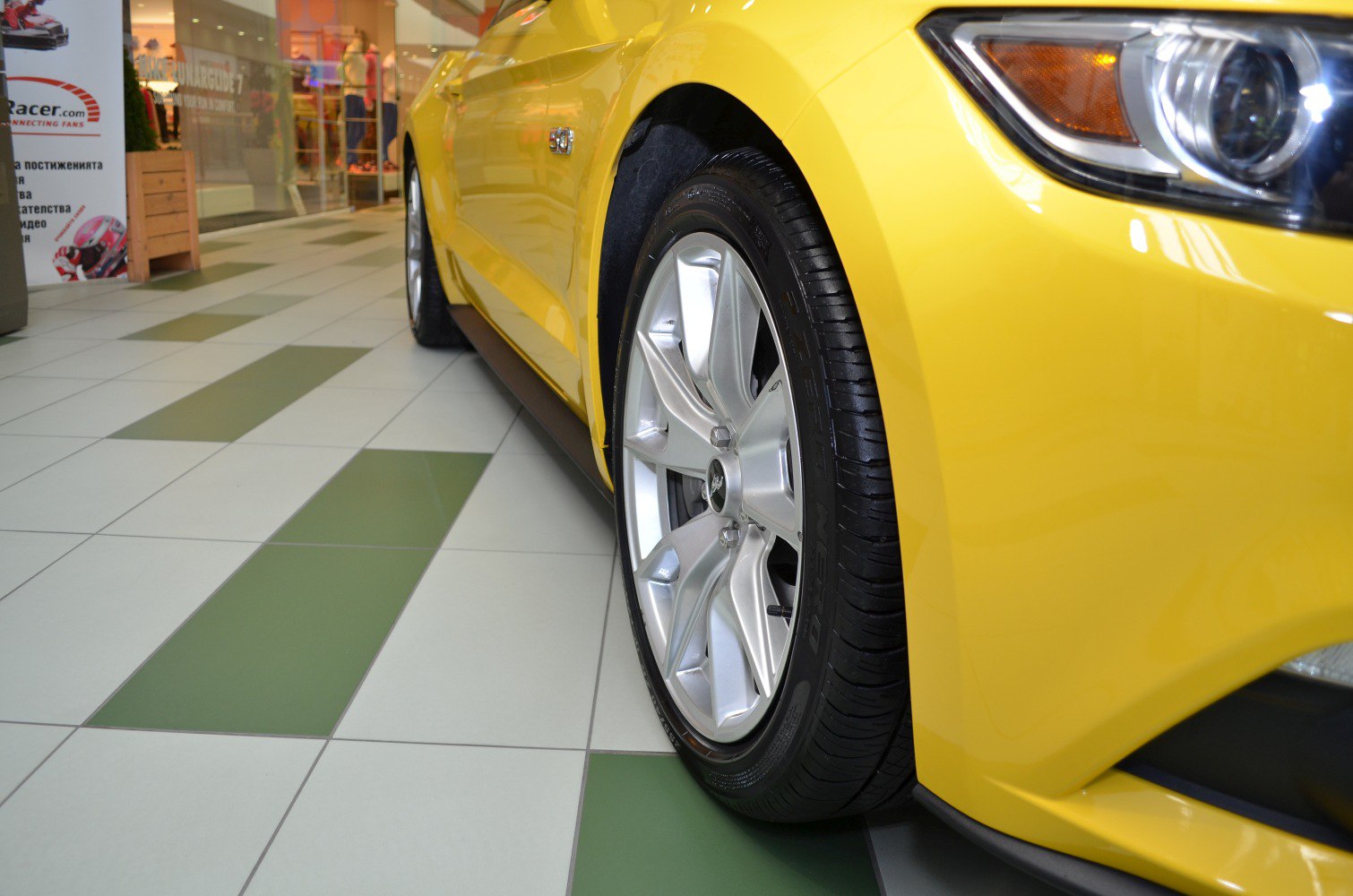 Front wheel and headlight close-up of a yellow sports vehicle