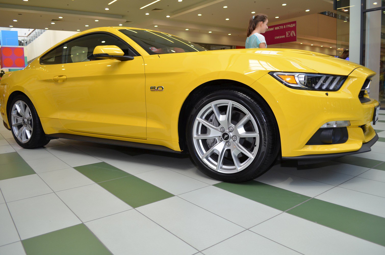 Yellow sports coupe with 5.0 badge and alloy wheels