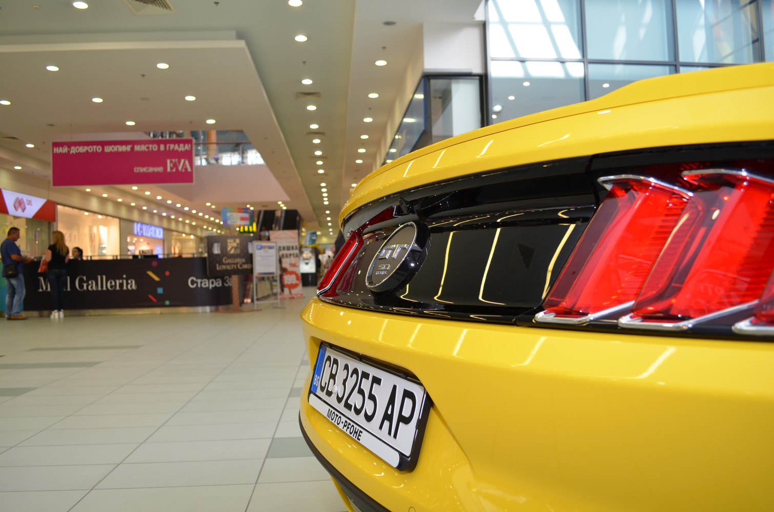 Yellow sports car rear with triple taillights and GT badge