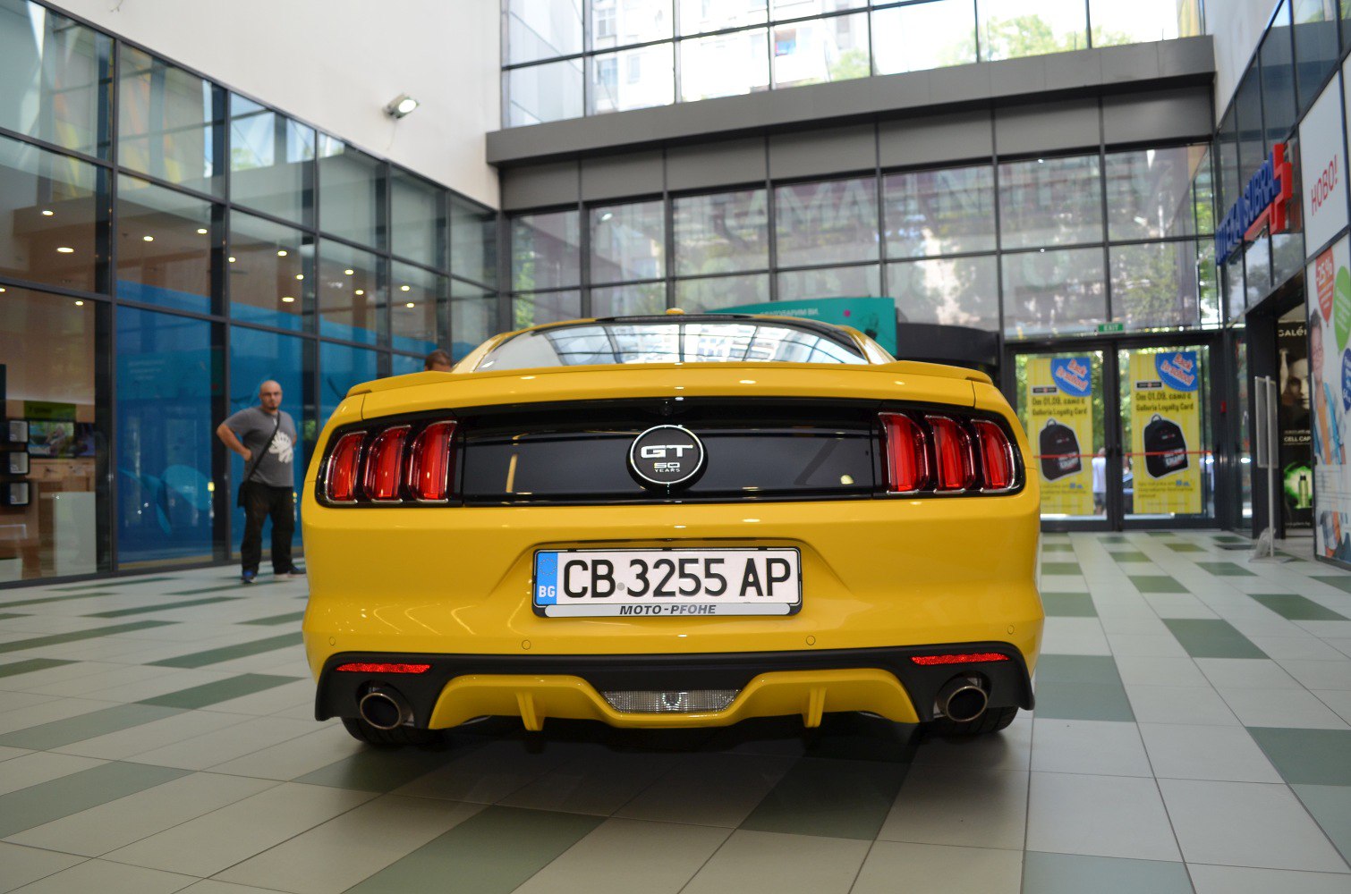 Yellow Mustang rear view with tri-bar taillights and dual exhausts